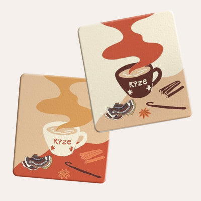 Two illustrated RYZE Chai coasters: one tan with a RYZE mug and turkey tail mushroom, one cream with a RYZE mug and...